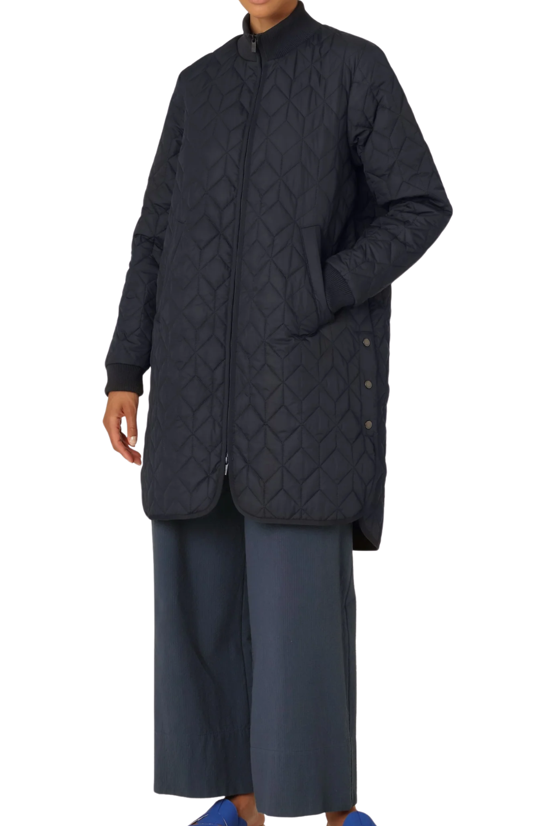 Woman wearing a dark blue quilted jacket and pants on a white background