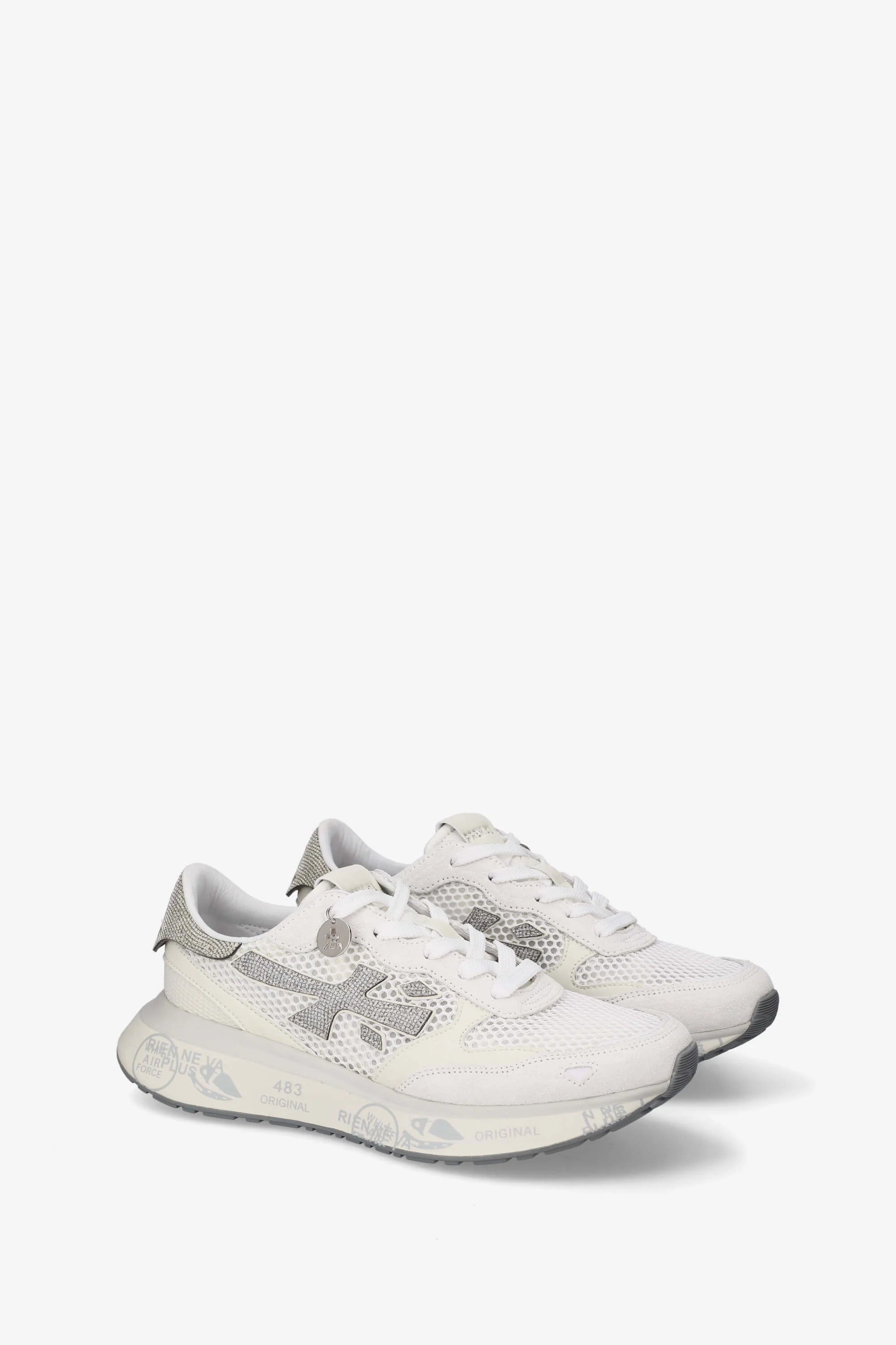 White sneakers with a brand logo on a light gray background