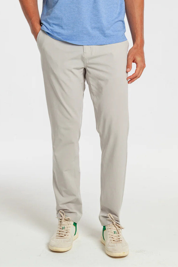 Person wearing light gray pants and a blue shirt on a white background
