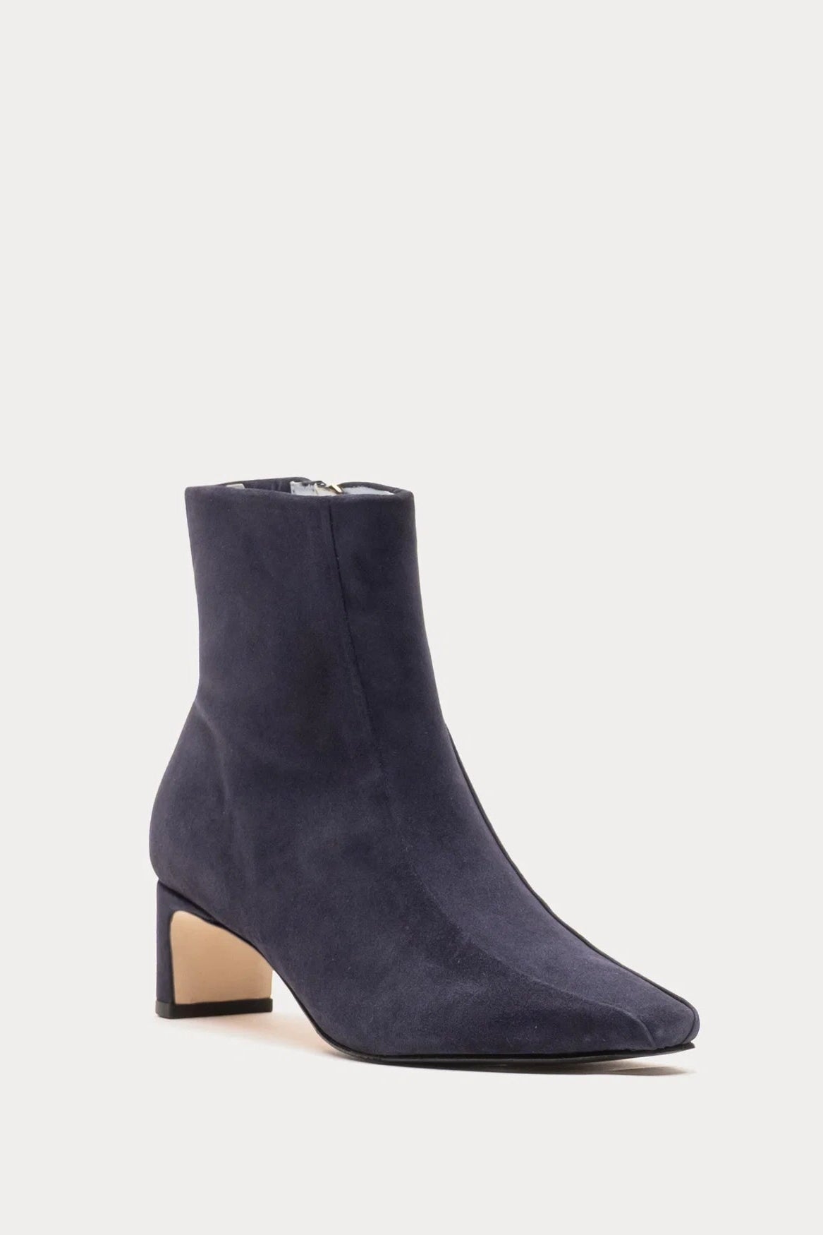 A single navy blue suede ankle boot with a block heel and pointed toe, shown from a side profile on a light gray background.