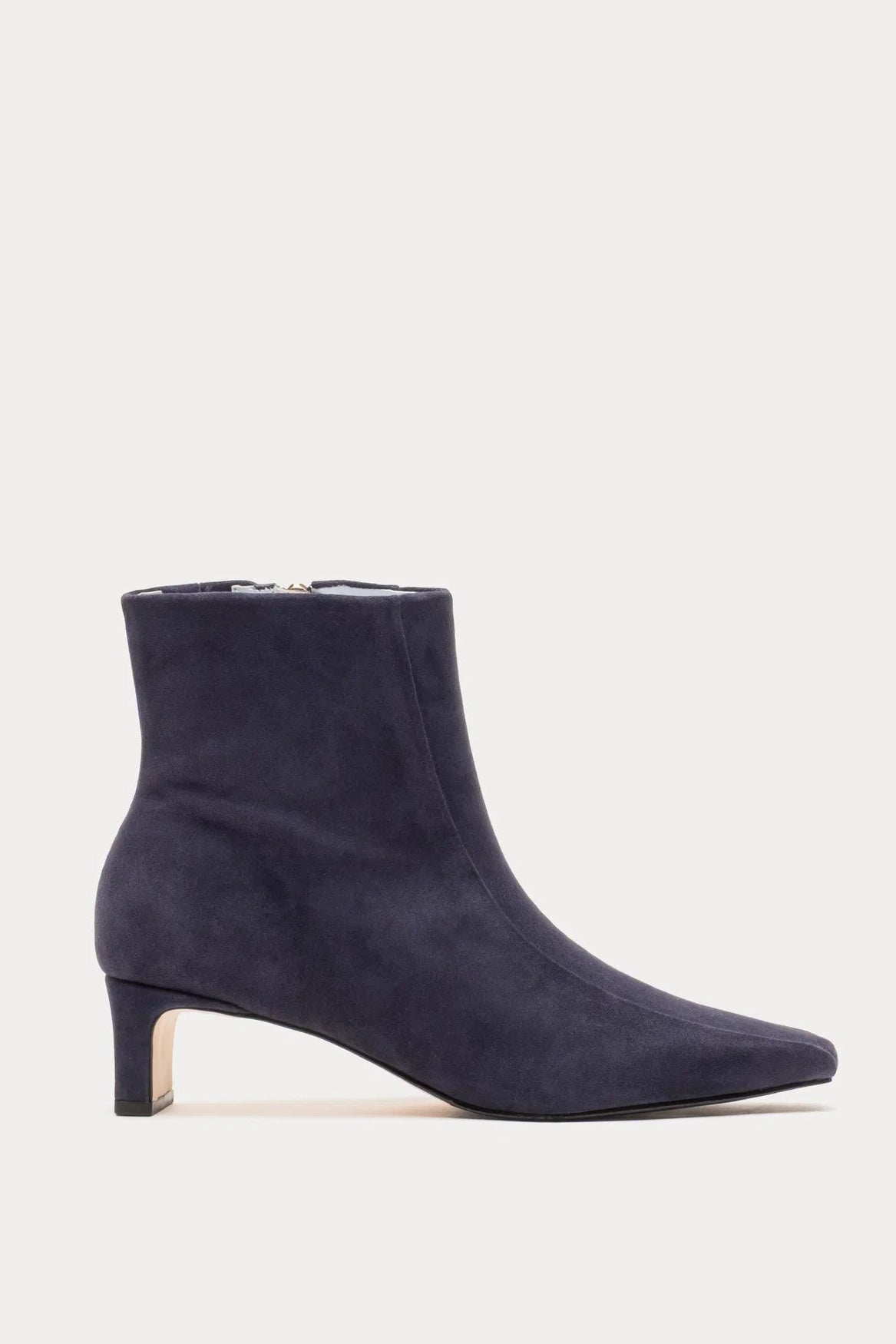 A dark navy blue suede ankle boot with a pointed toe and a low block heel, shown in profile against a light gray background.