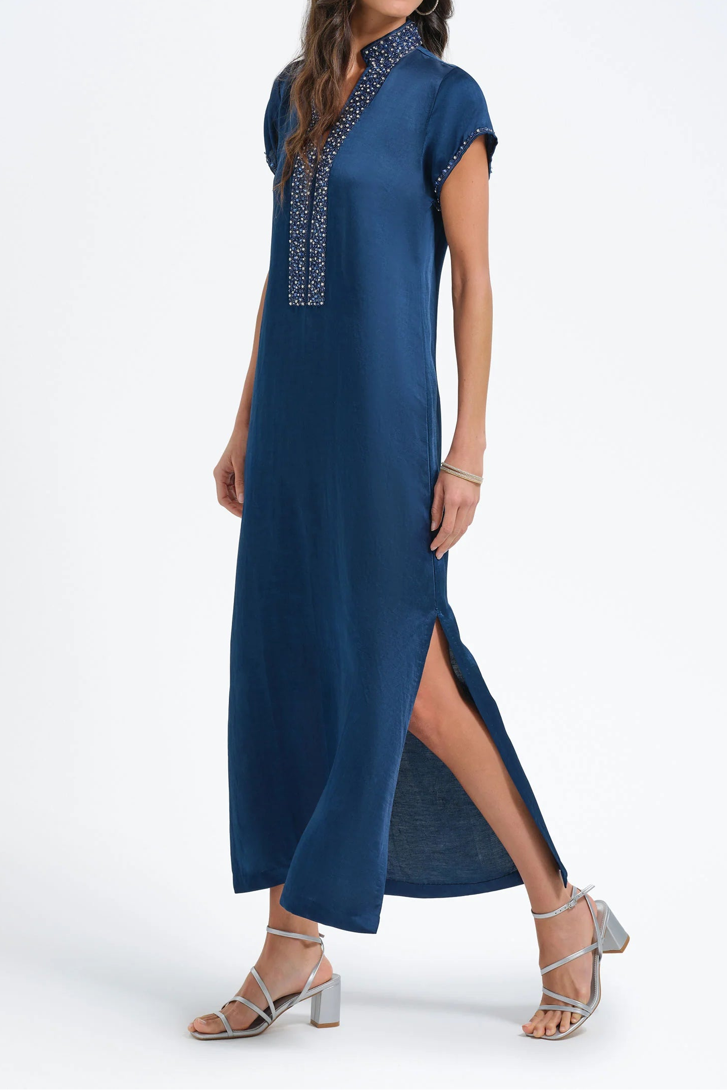 Woman wearing a blue dress with embroidery on a white background