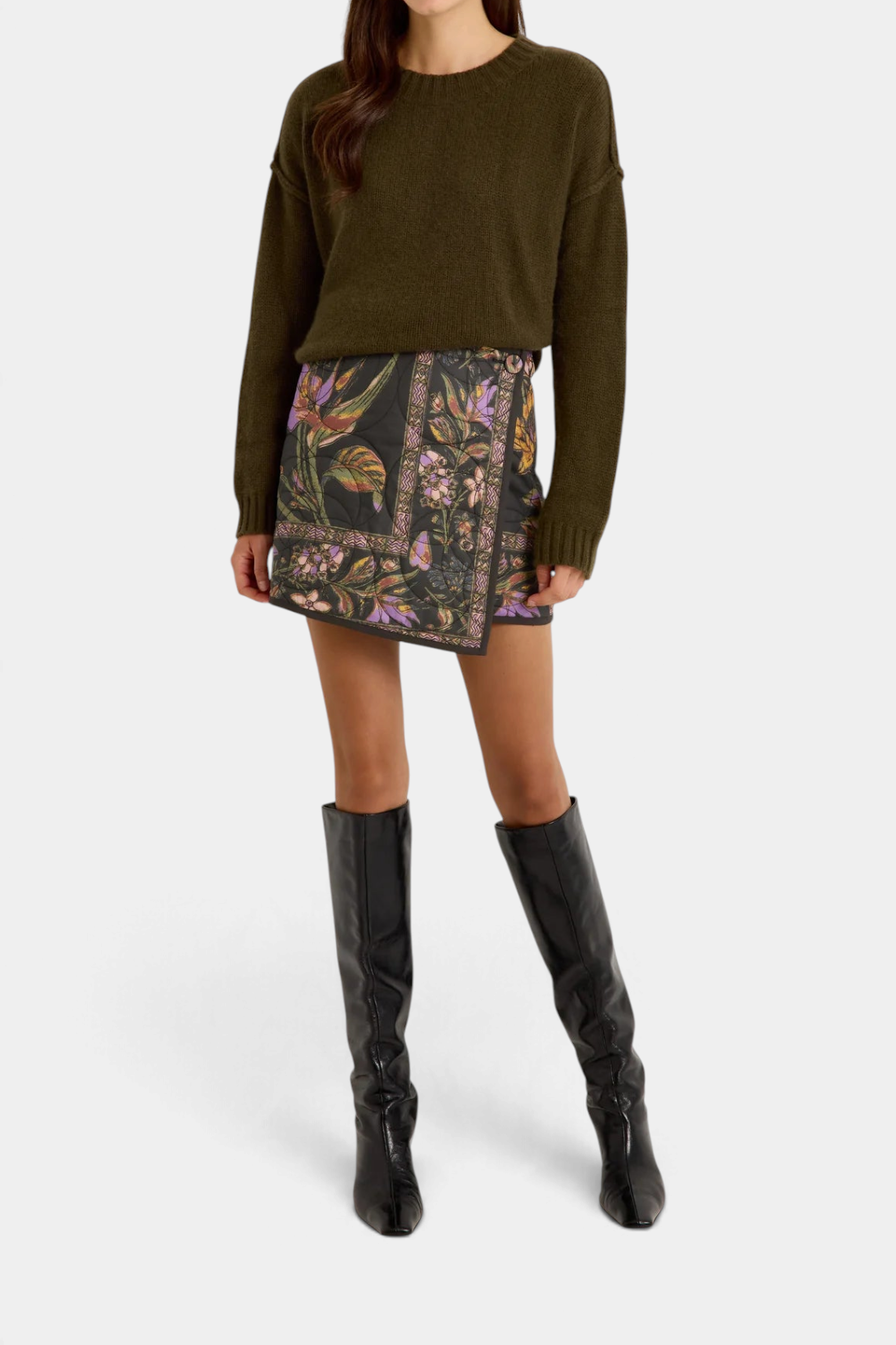 Marie Oliver Ozzie sweater in olive green cashmere worn with a floral print mini skirt and black knee-high boots