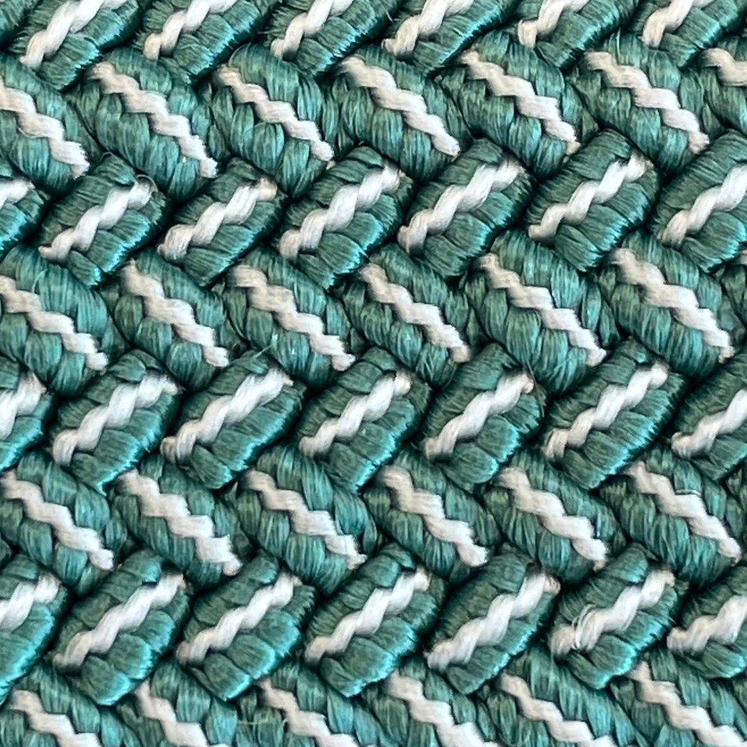 A close-up of a woven textile pattern featuring alternating diagonal stripes of teal green and off-white.