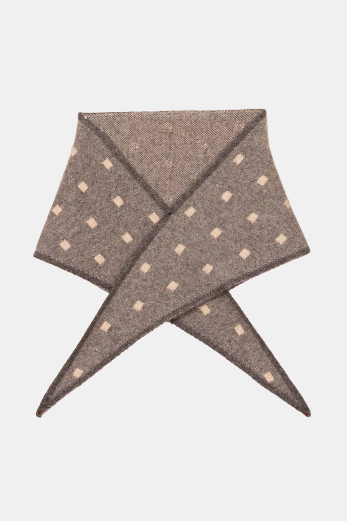 A folded gray pocket square with small white diamond patterns, displayed on a textured beige fabric background.