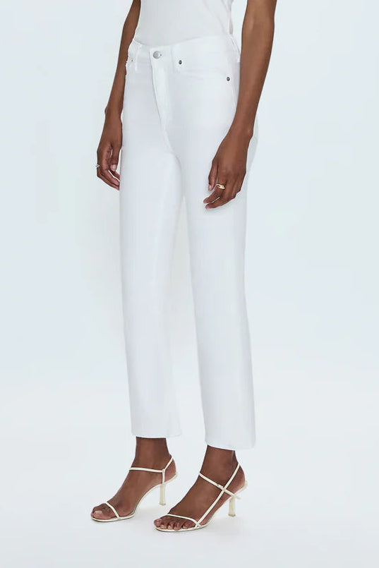Woman wearing a white sleeveless top and pants on a light gray background