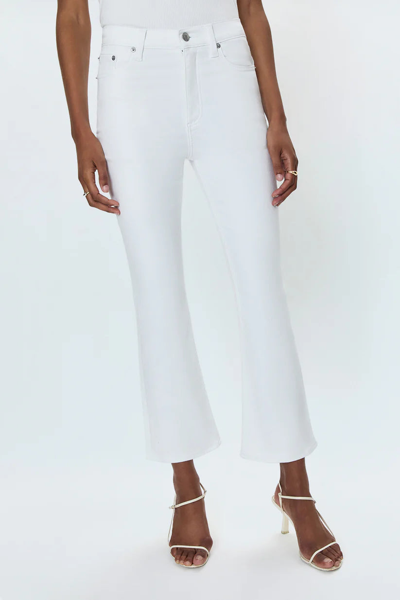 Person wearing white jeans and strappy sandals on a white background