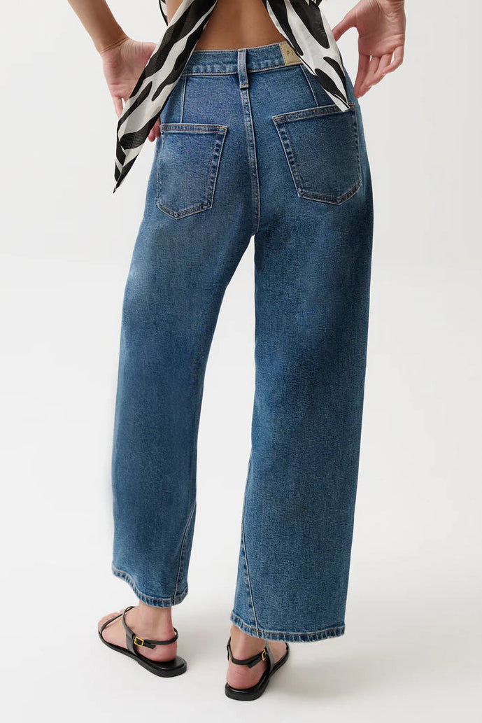 Person wearing a zebra print top and blue jeans on a white background