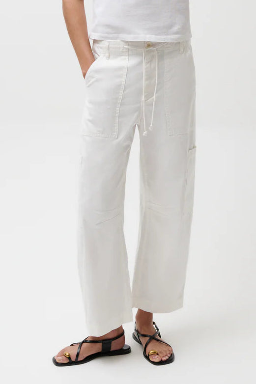 Person wearing a white t-shirt, white pants, and a green cap on a white background