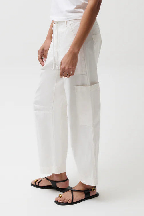 Person wearing a white t-shirt and pants with a green cap on a white background