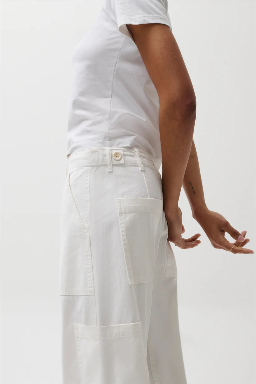 Person wearing a white outfit with pants on a plain background