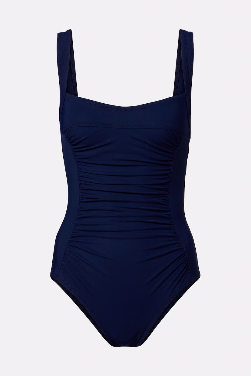 A dark navy blue one-piece swimsuit with a square neckline, wide shoulder straps, and a ruched, gathered bodice, shown against a light gray background.