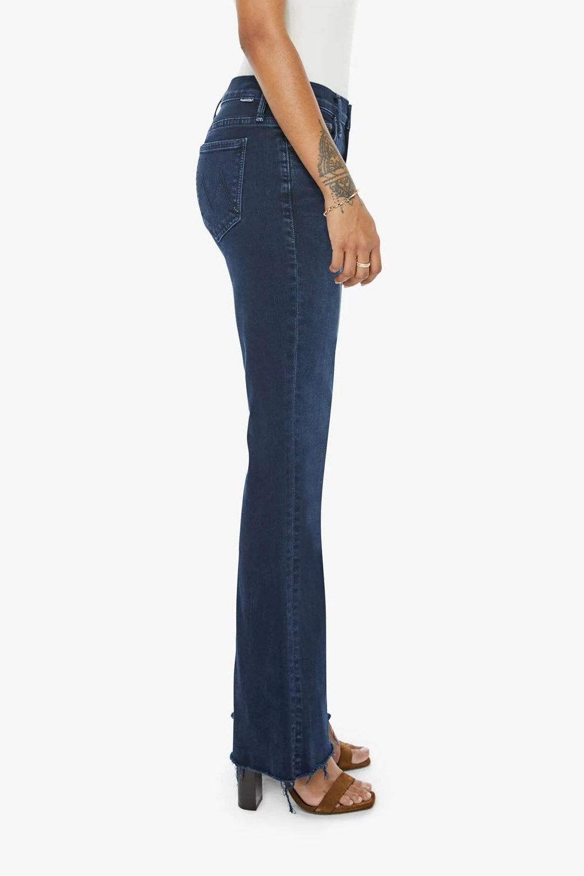 Woman wearing a white top and dark blue jeans on a white background