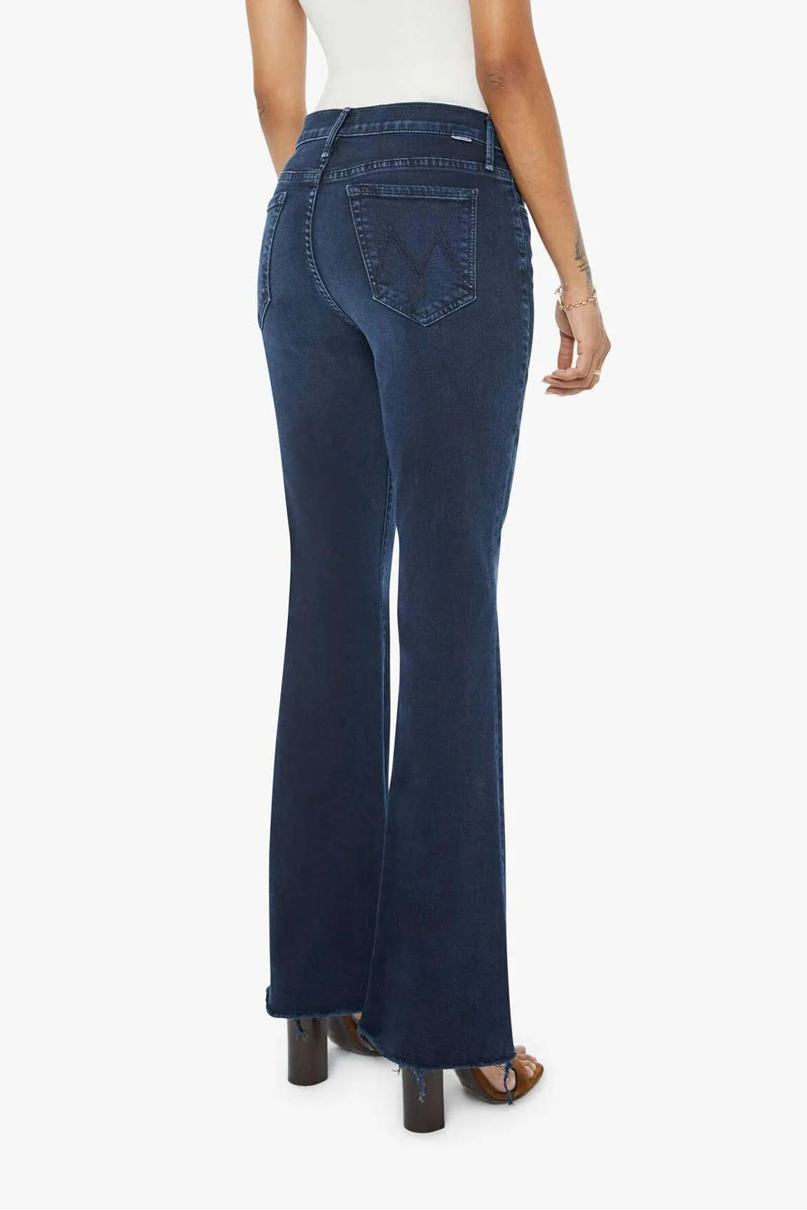 Woman wearing blue jeans and a white top on a white background
