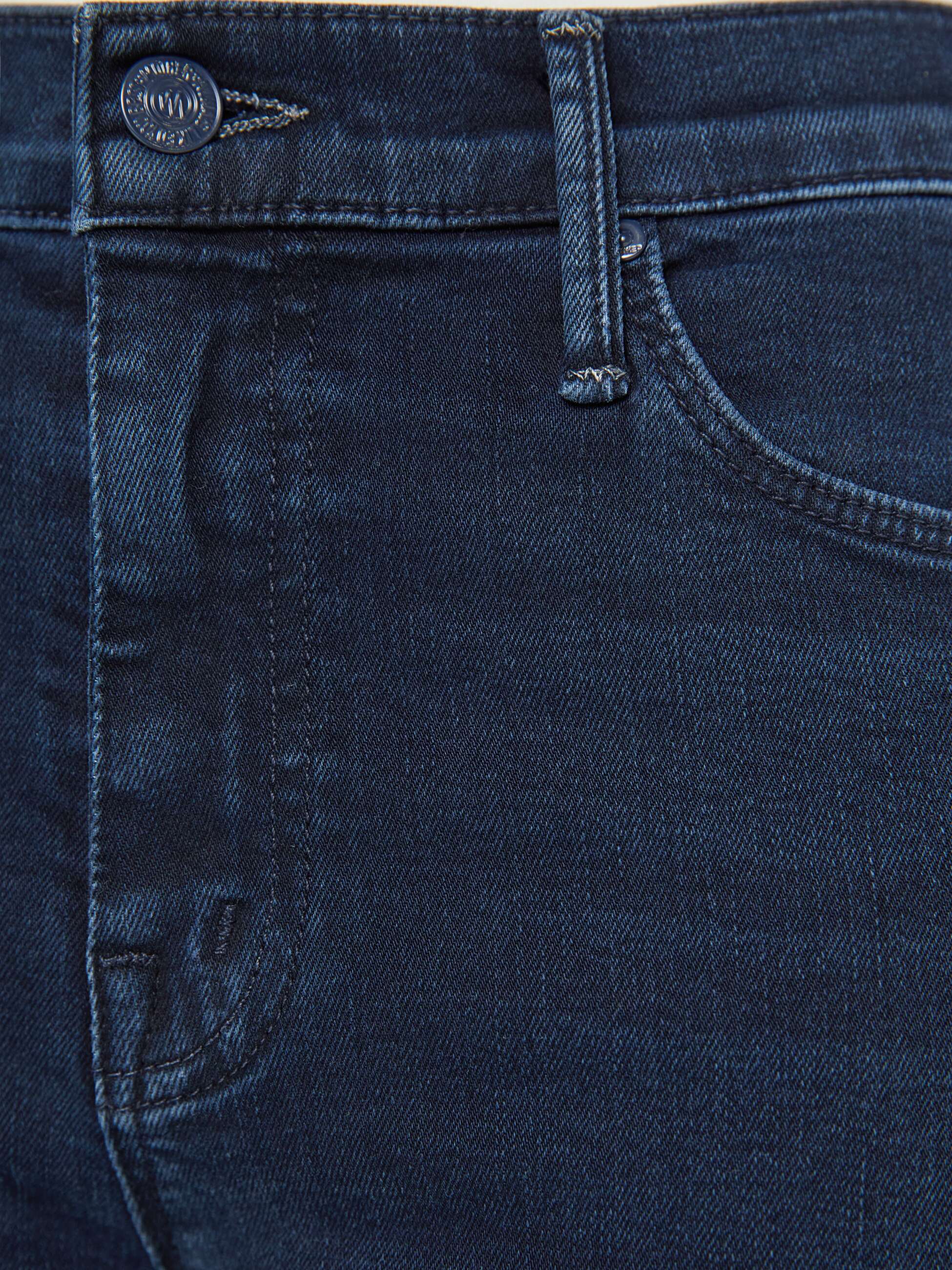 Close-up of dark blue denim fabric with stitching details