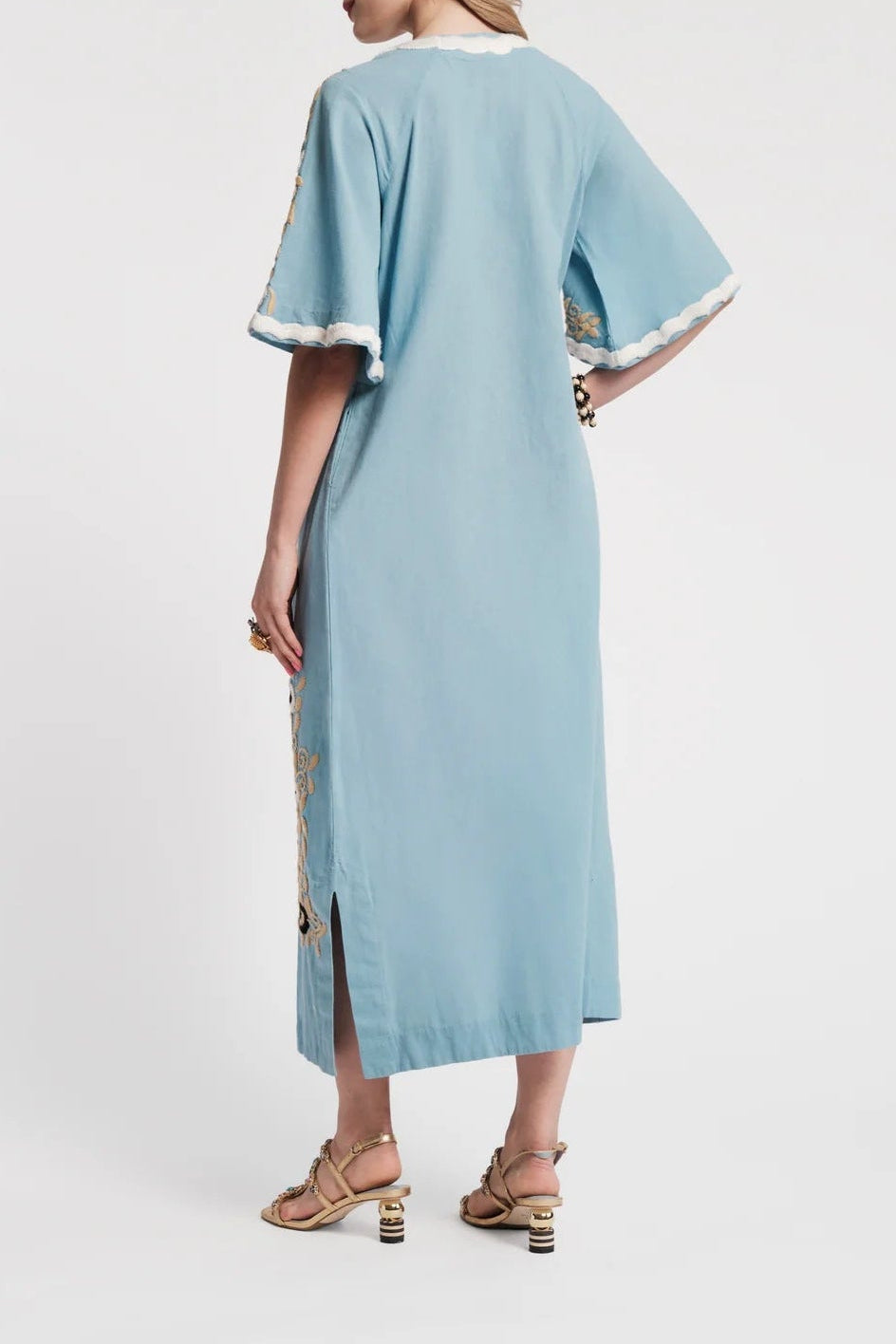 Woman wearing a light blue dress with white trim on a white background