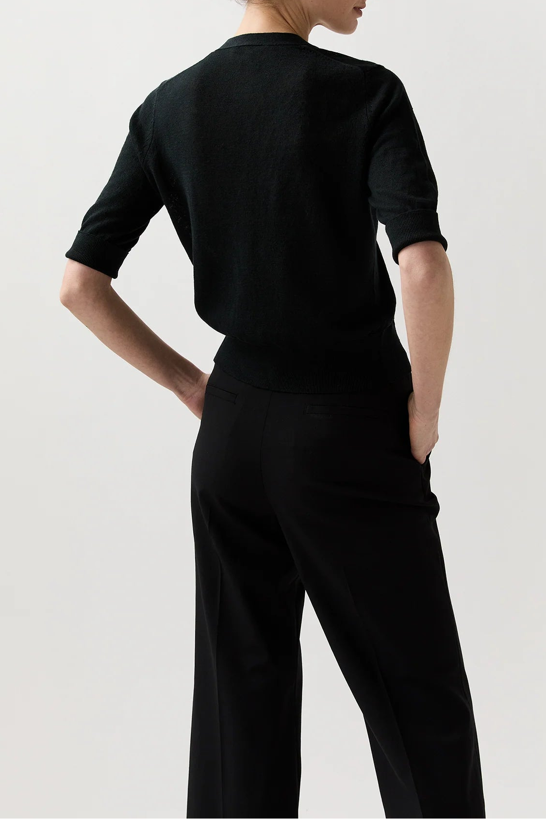 Woman wearing a black outfit against a white background