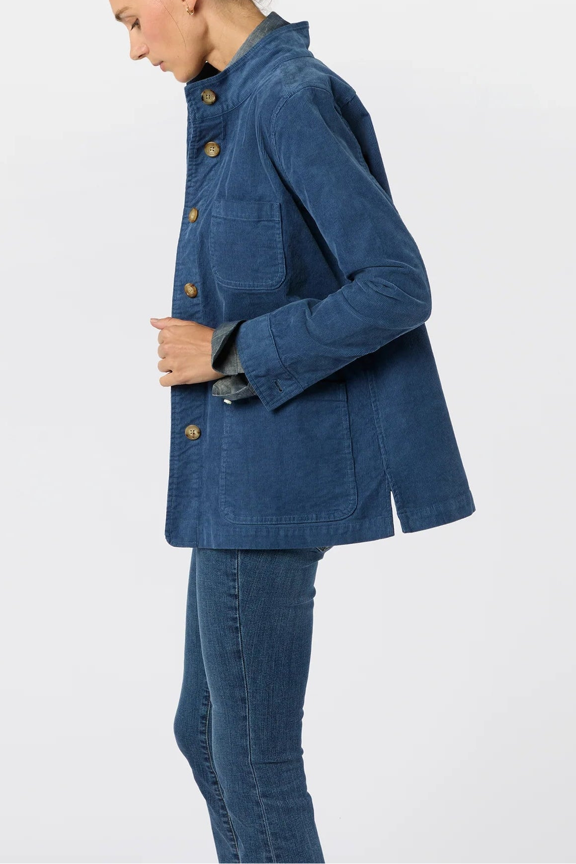 Woman wearing a blue jacket and jeans on a white background
