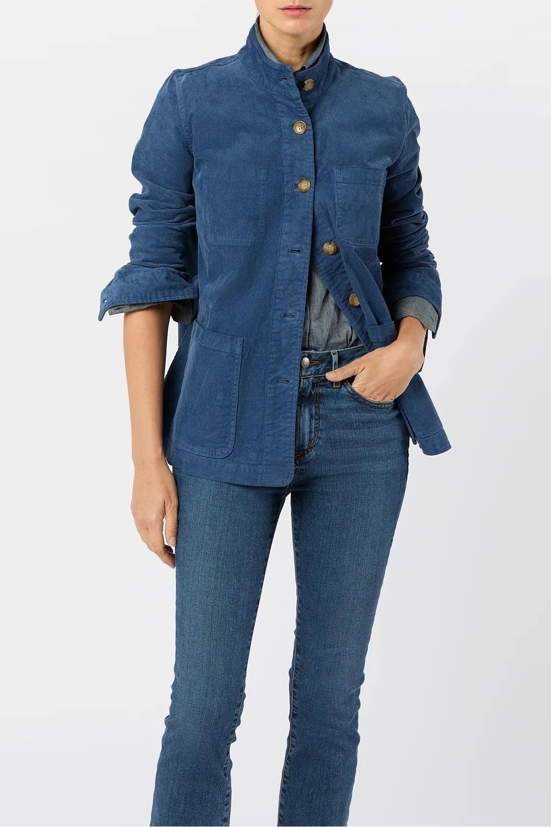 Woman wearing a blue denim jacket and jeans on a white background