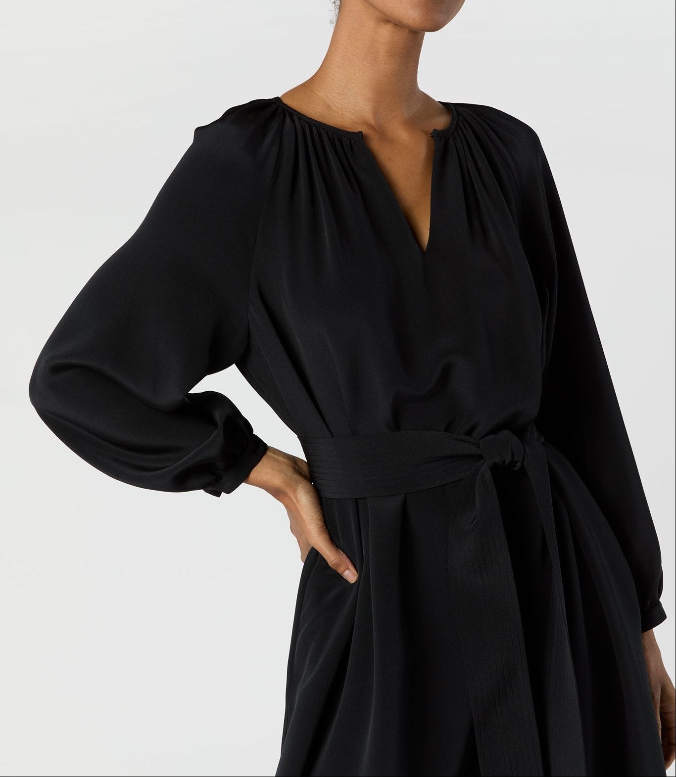 Woman wearing a black dress against a plain background