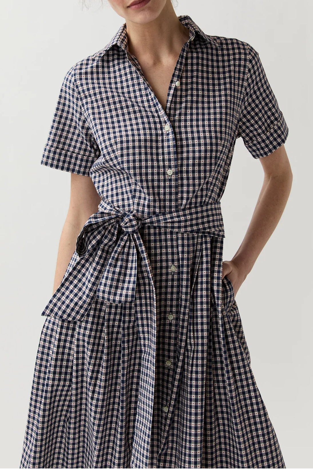 Woman wearing a black and white checkered dress on a plain background