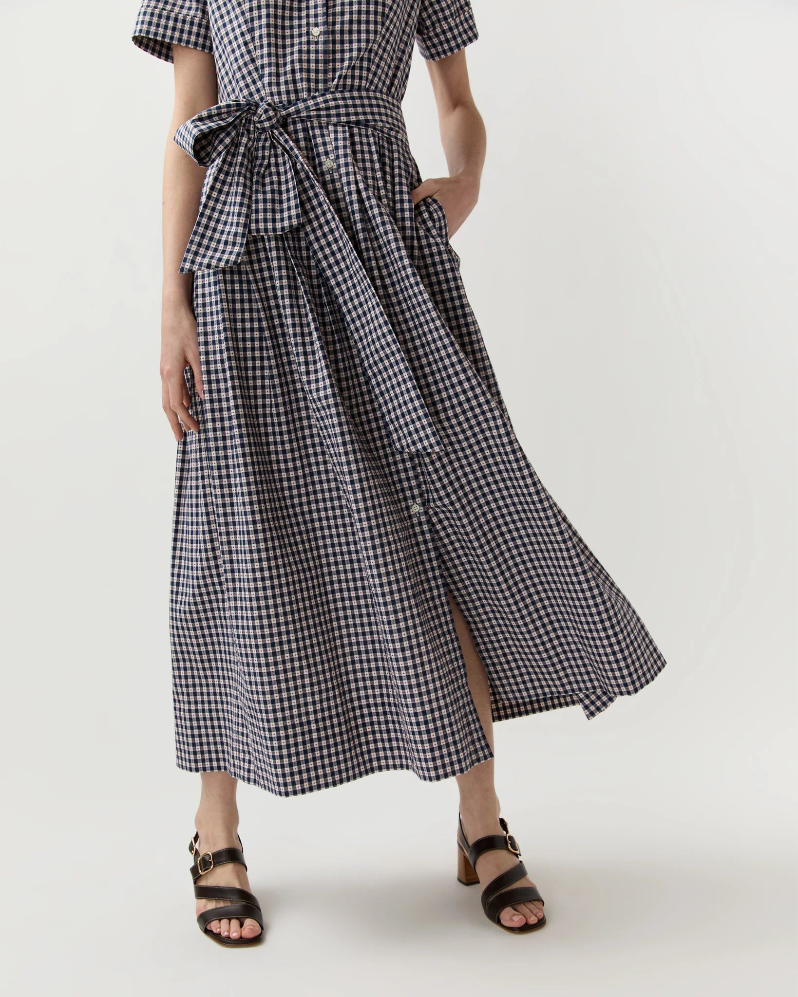 Person wearing a black and white checkered dress on a white background