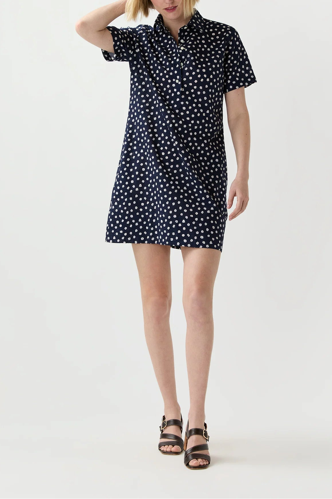 Woman wearing a black dress with white polka dots on a white background