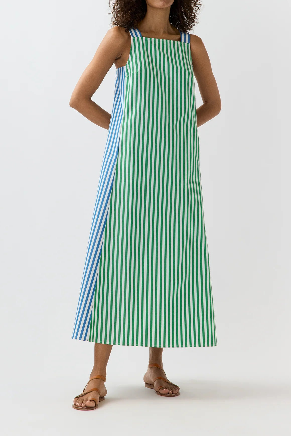 Woman wearing a green and blue striped dress on a white background