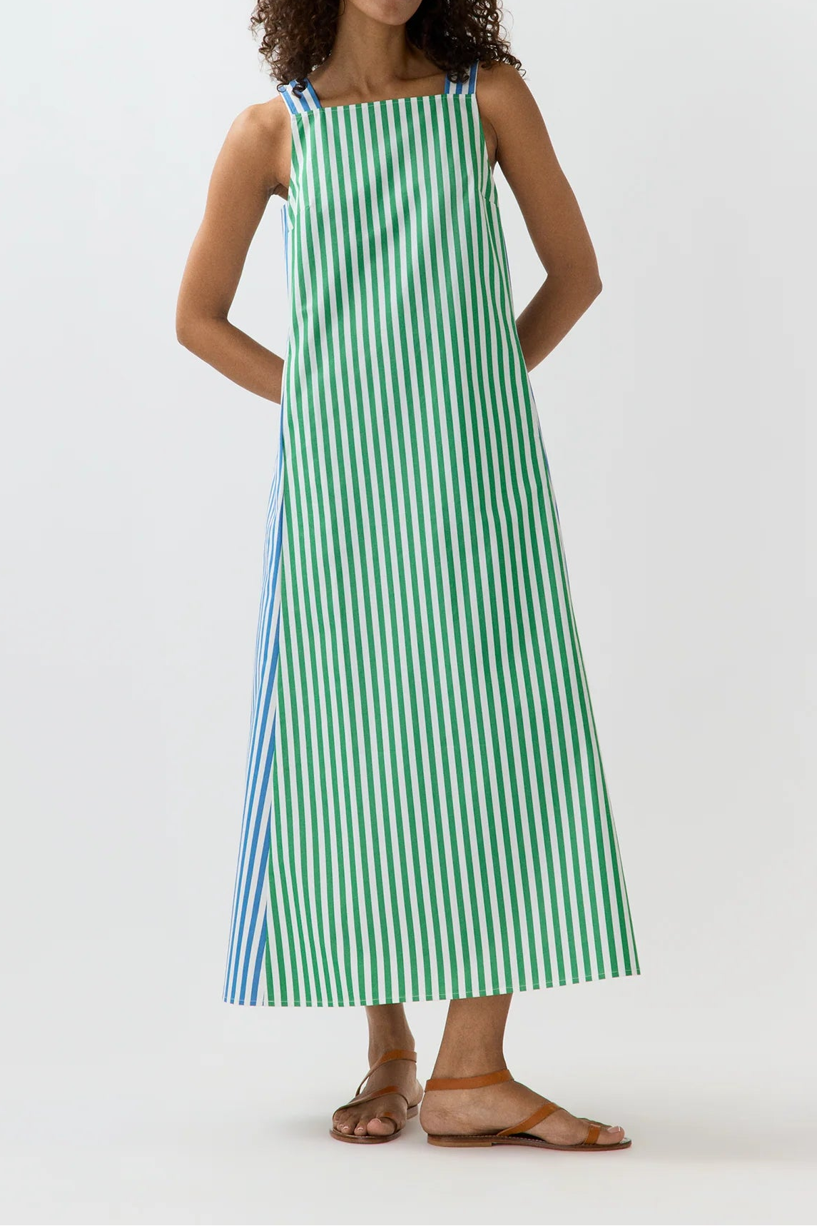 Woman wearing a green and white striped dress on a white background