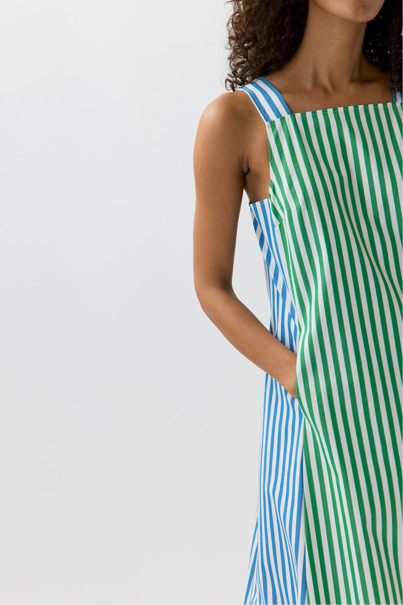 Woman wearing a blue and green striped dress on a white background