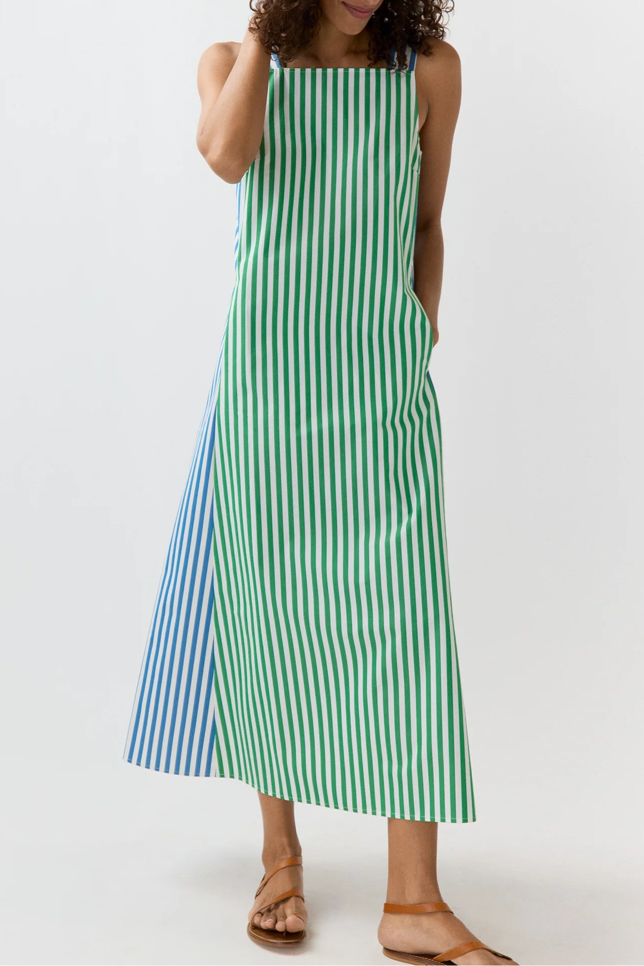 Woman wearing a green and blue striped dress on a white background