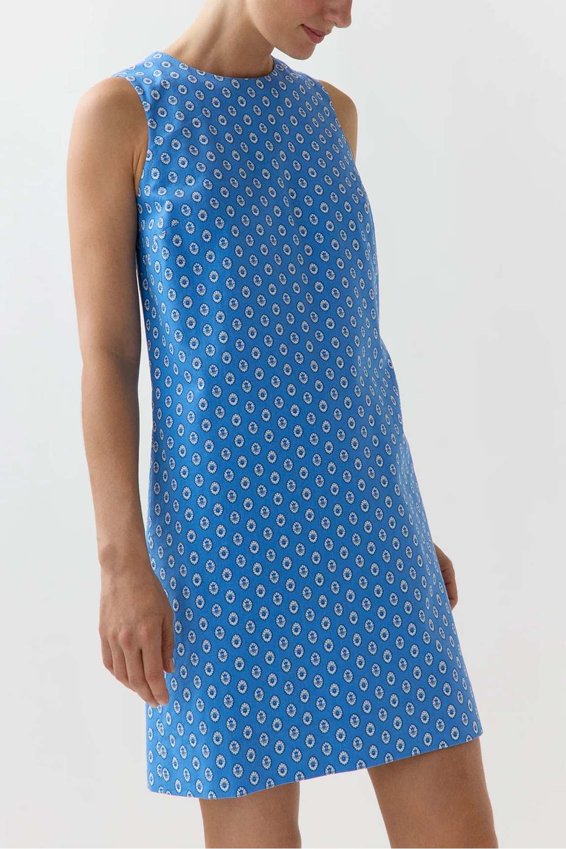 Woman wearing a blue patterned dress on a white background