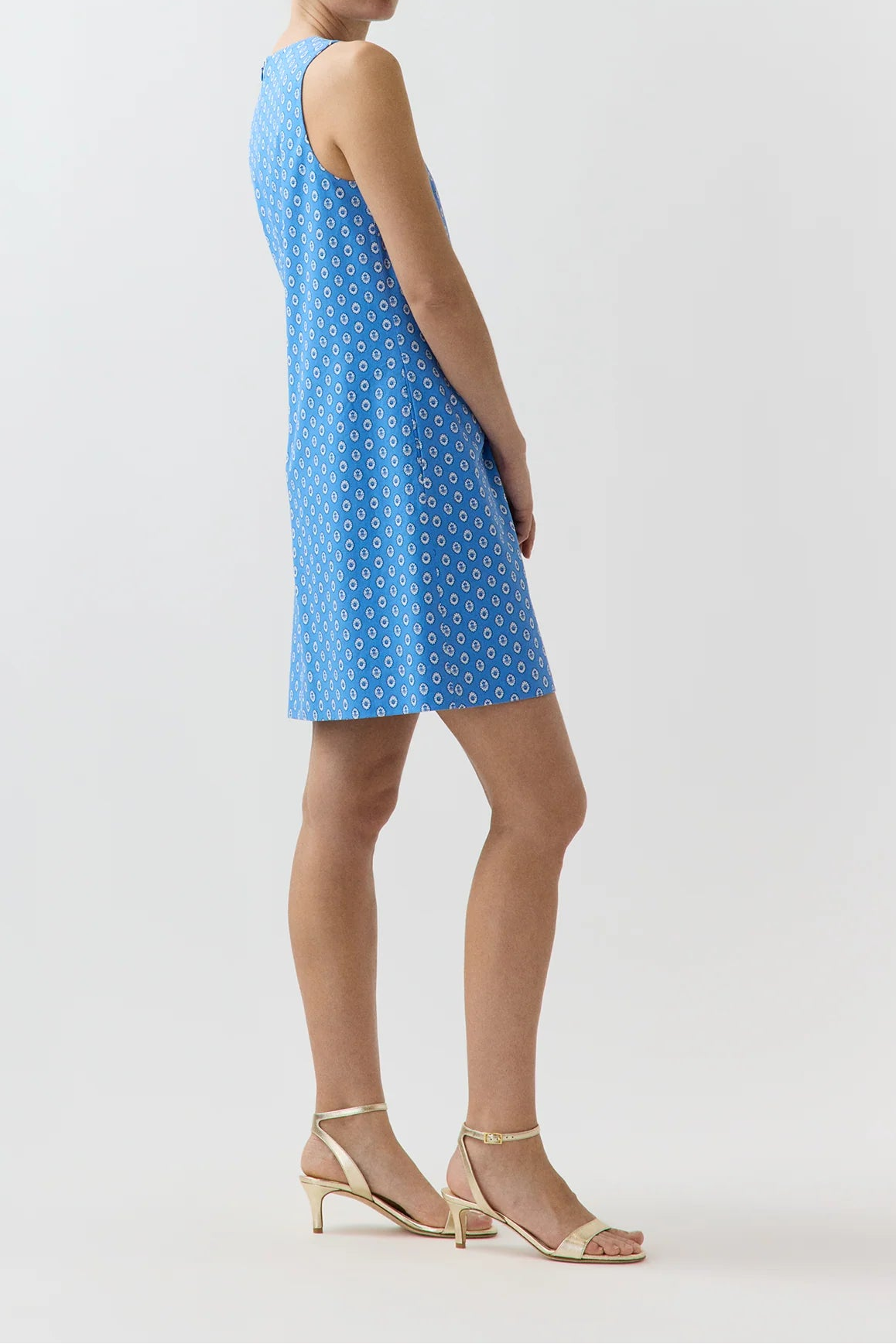 Woman wearing a blue polka dot dress on a white background