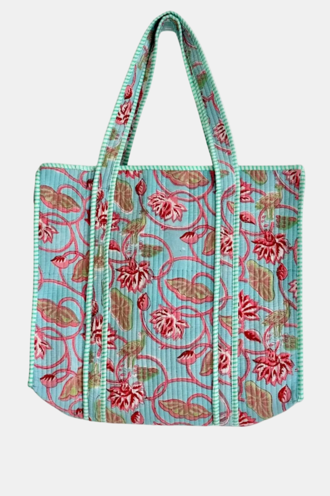 A quilted fabric tote bag featuring a floral vine pattern in pink, green, and brown on a light blue background, with striped handles.