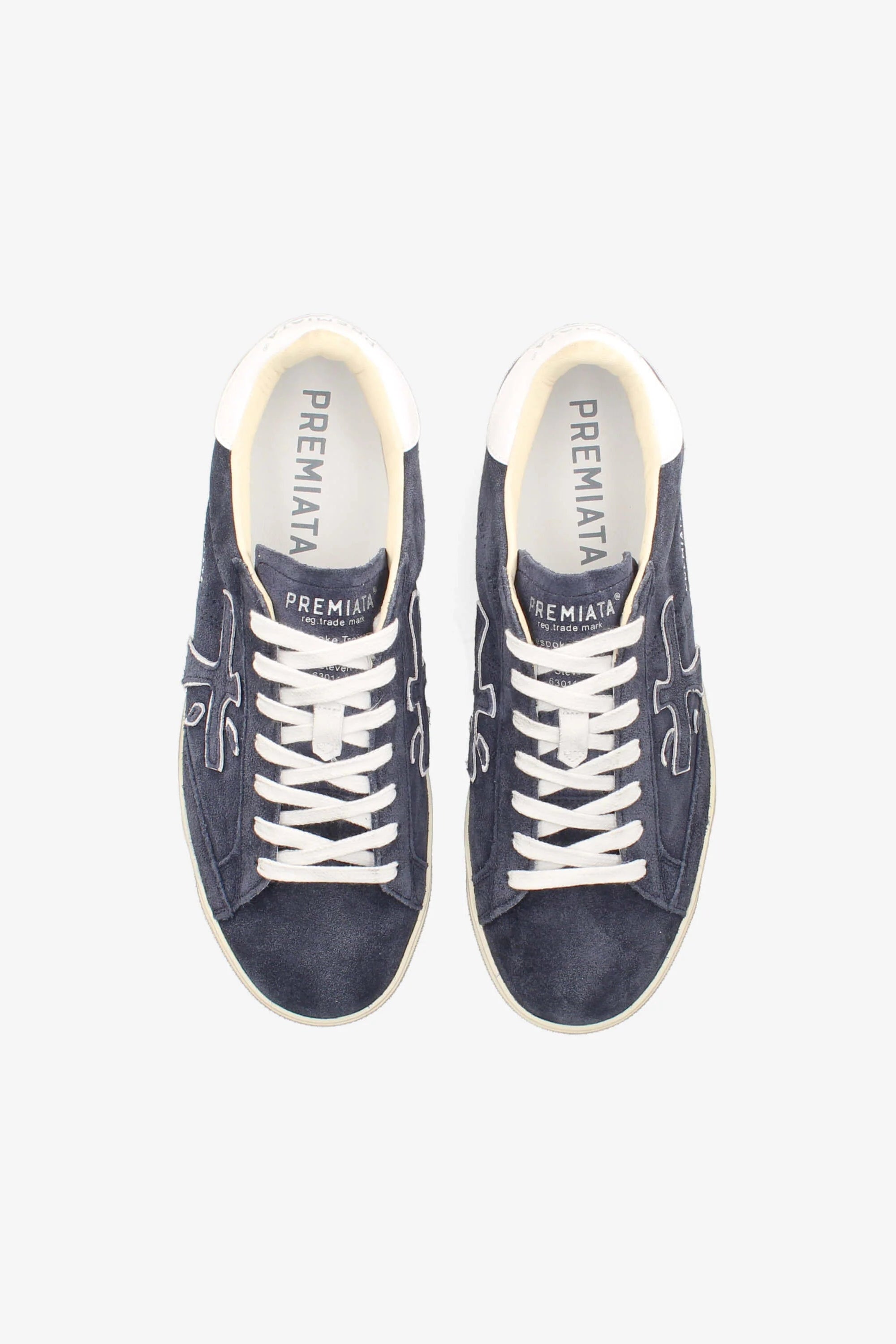 Pair of navy blue sneakers with white laces on a white background