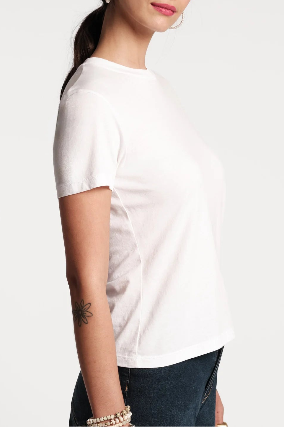 Woman wearing a white t-shirt against a plain background