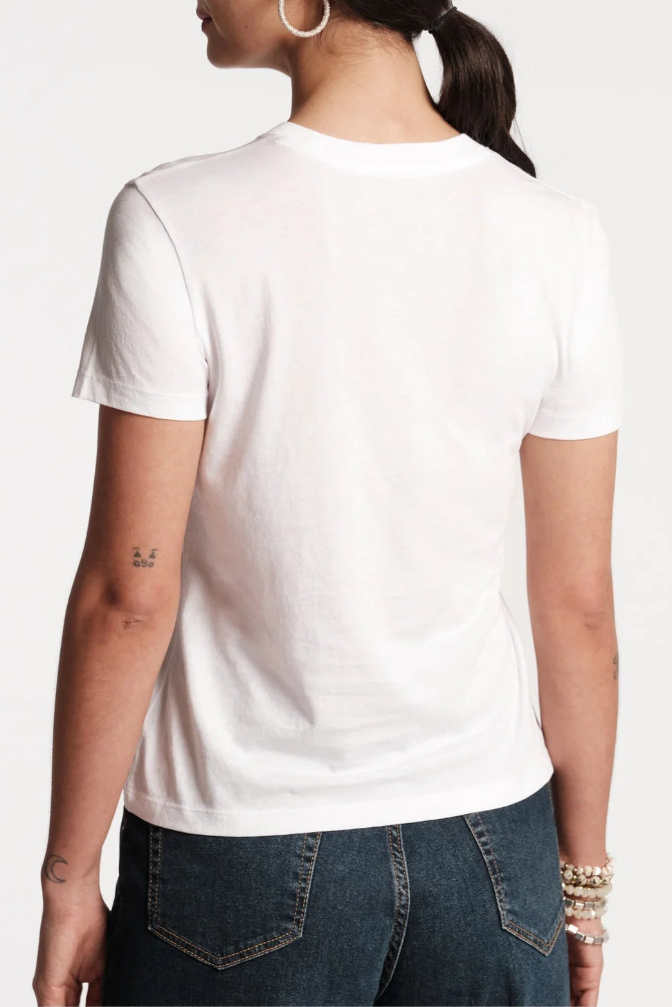 Person wearing a plain white t-shirt on a light gray background