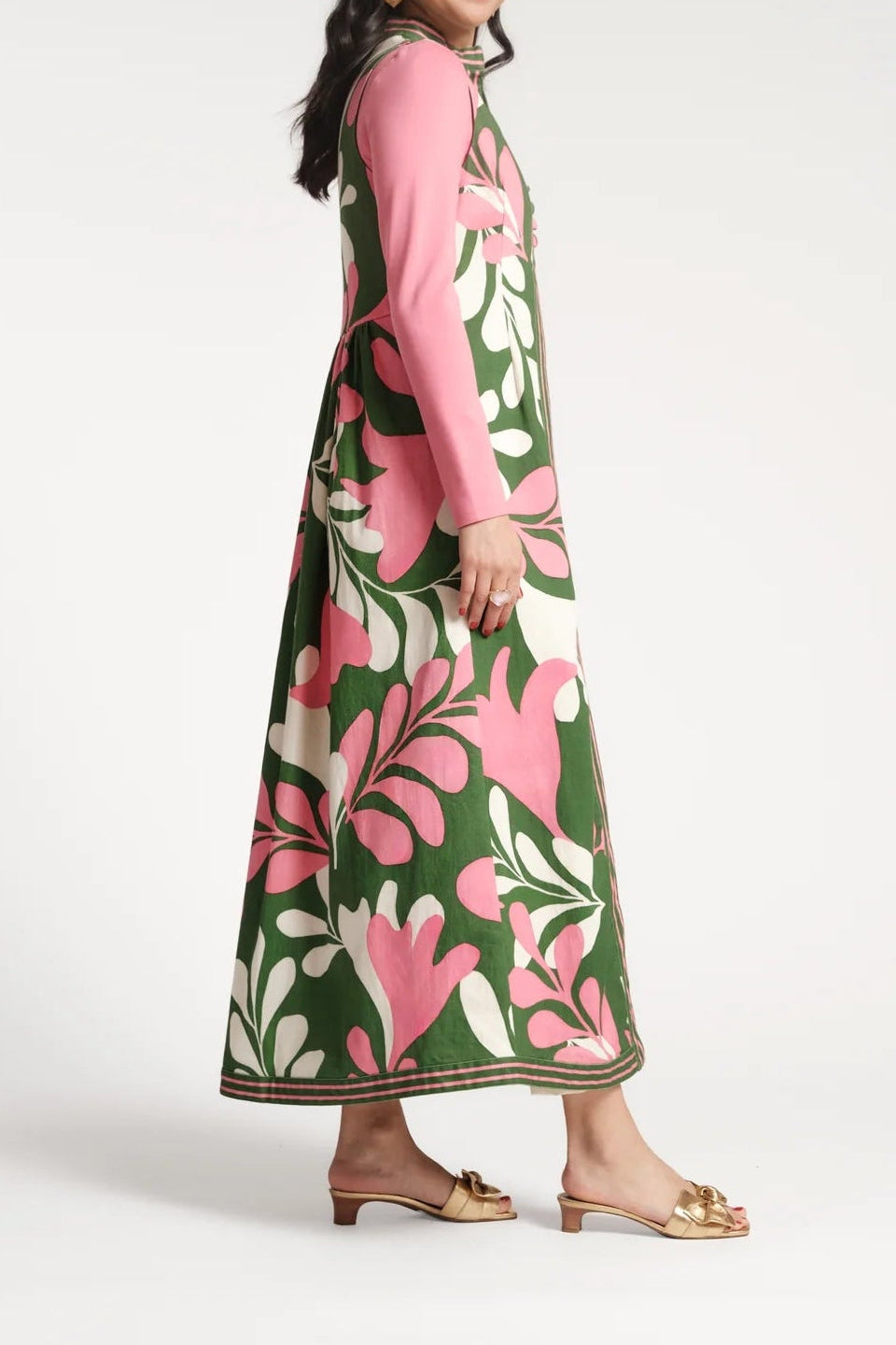 Woman wearing a pink and green floral dress on a white background