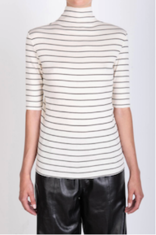 Person wearing a striped turtleneck shirt and black pants on a white background