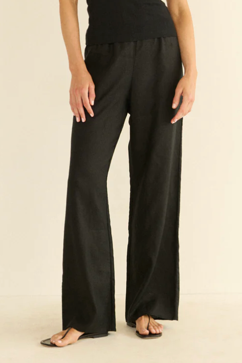 Woman wearing a black outfit on a beige background