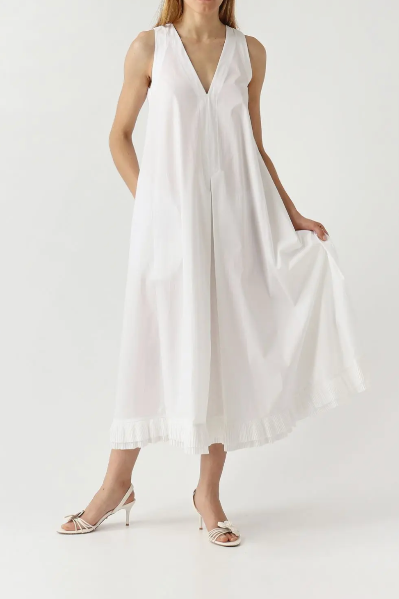 Woman wearing a white sleeveless dress on a plain background