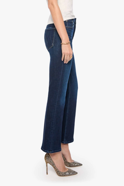 A side profile view of a model wearing dark blue wide-leg cropped jeans, a white sleeveless top, and leopard-print high heels against a plain white background.
