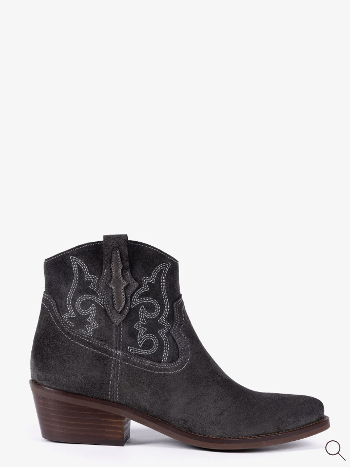 A dark gray suede western ankle boot with white embroidered detailing on the shaft and a brown stacked heel, shown from a side profile against a plain white background.