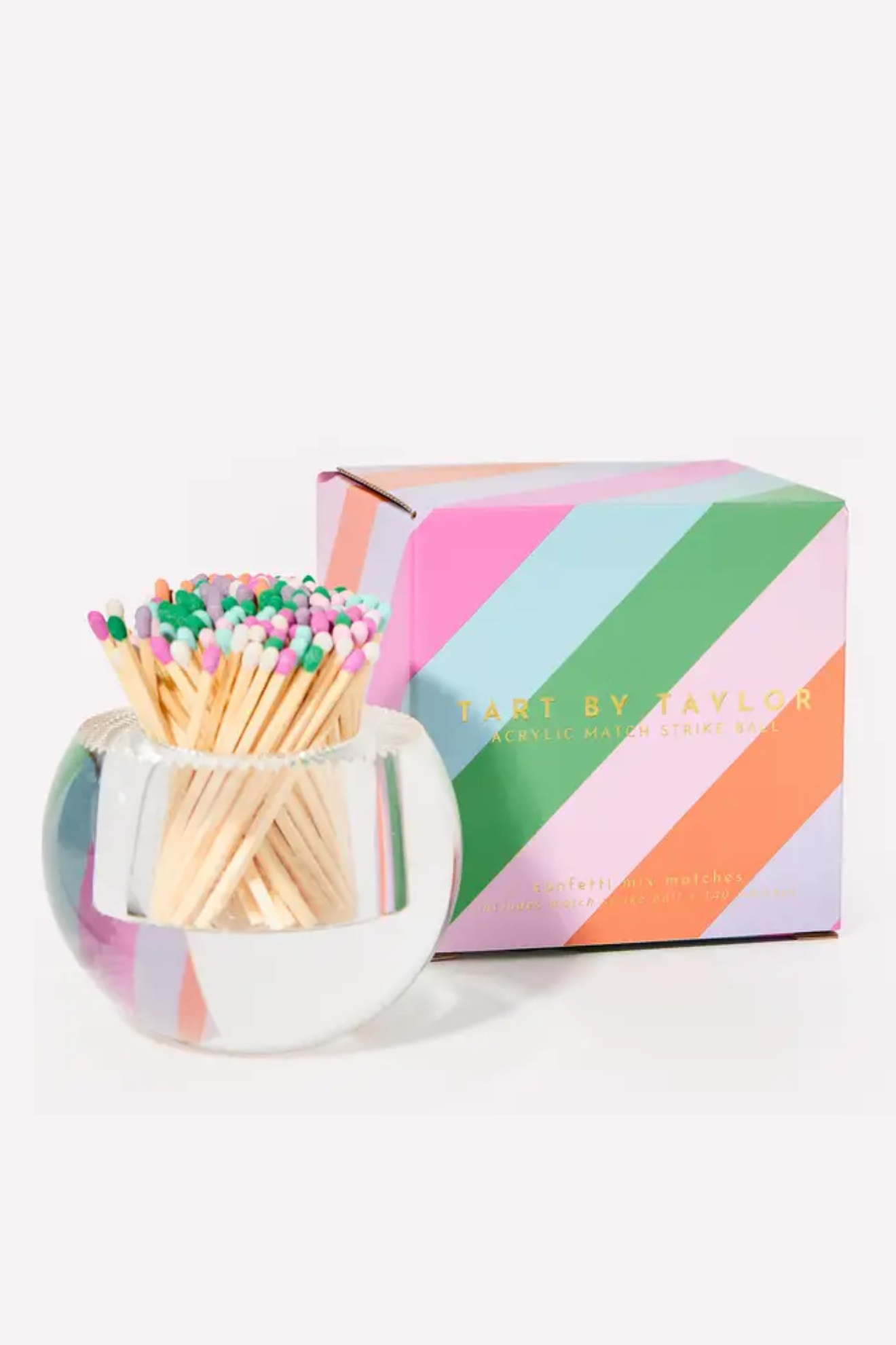 Matches in a glass holder with a colorful striped box on a white background