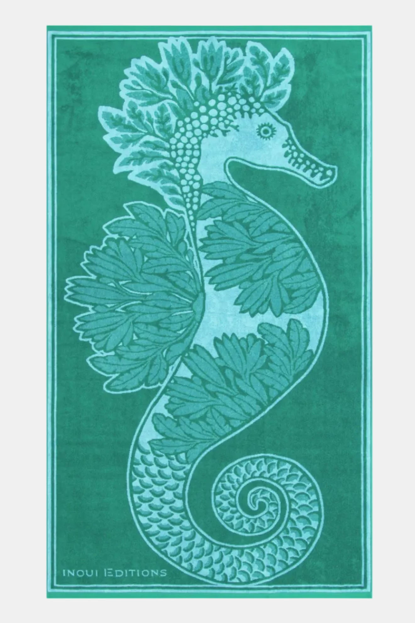 A rectangular green towel or mat featuring a large seahorse and leafy marine design in light aqua and teal, with the text 'INOUI EDITIONS' at the bottom left.