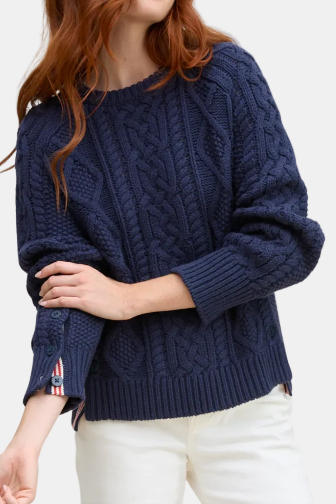 Woman wearing a navy blue cable knit sweater on a white background