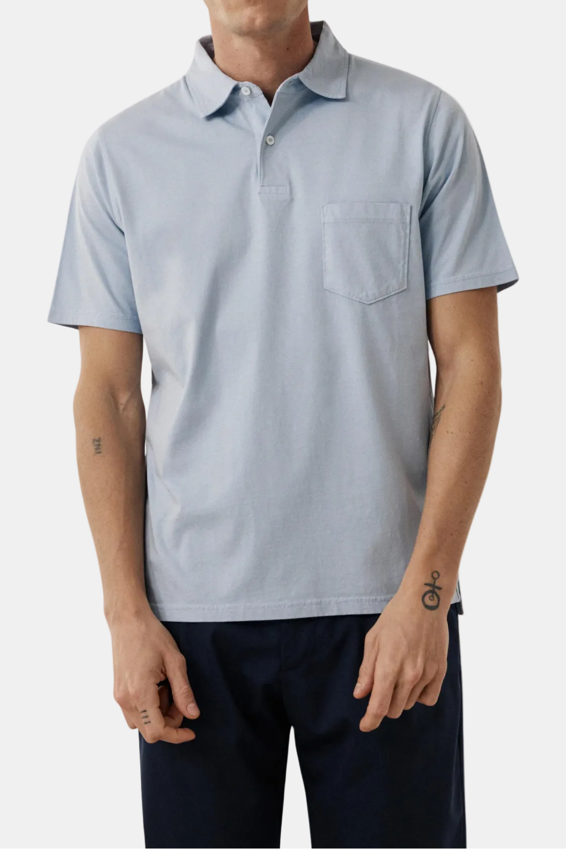 Man wearing a light blue polo shirt with a white background