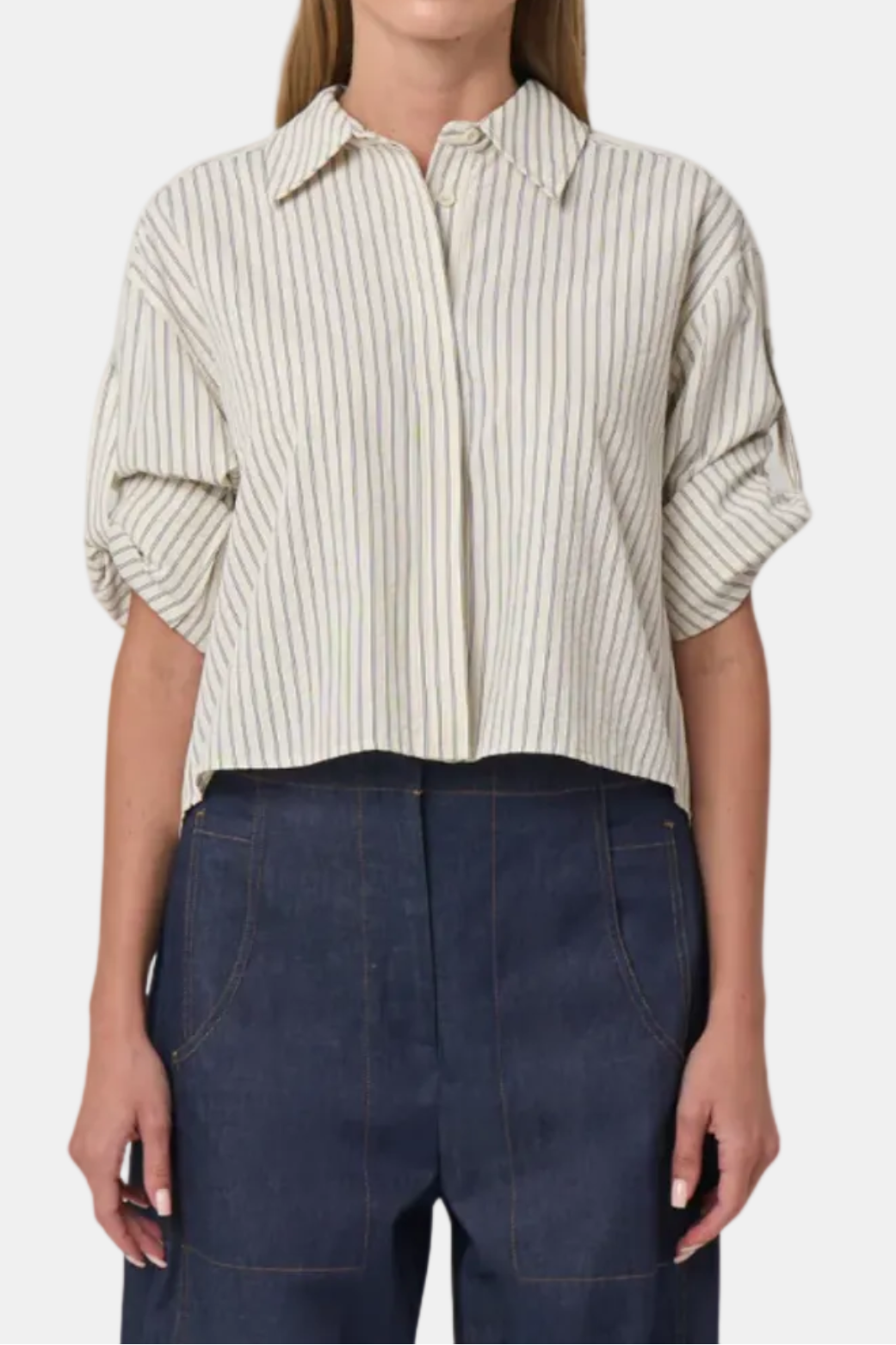 Woman wearing a striped shirt and dark pants on a white background