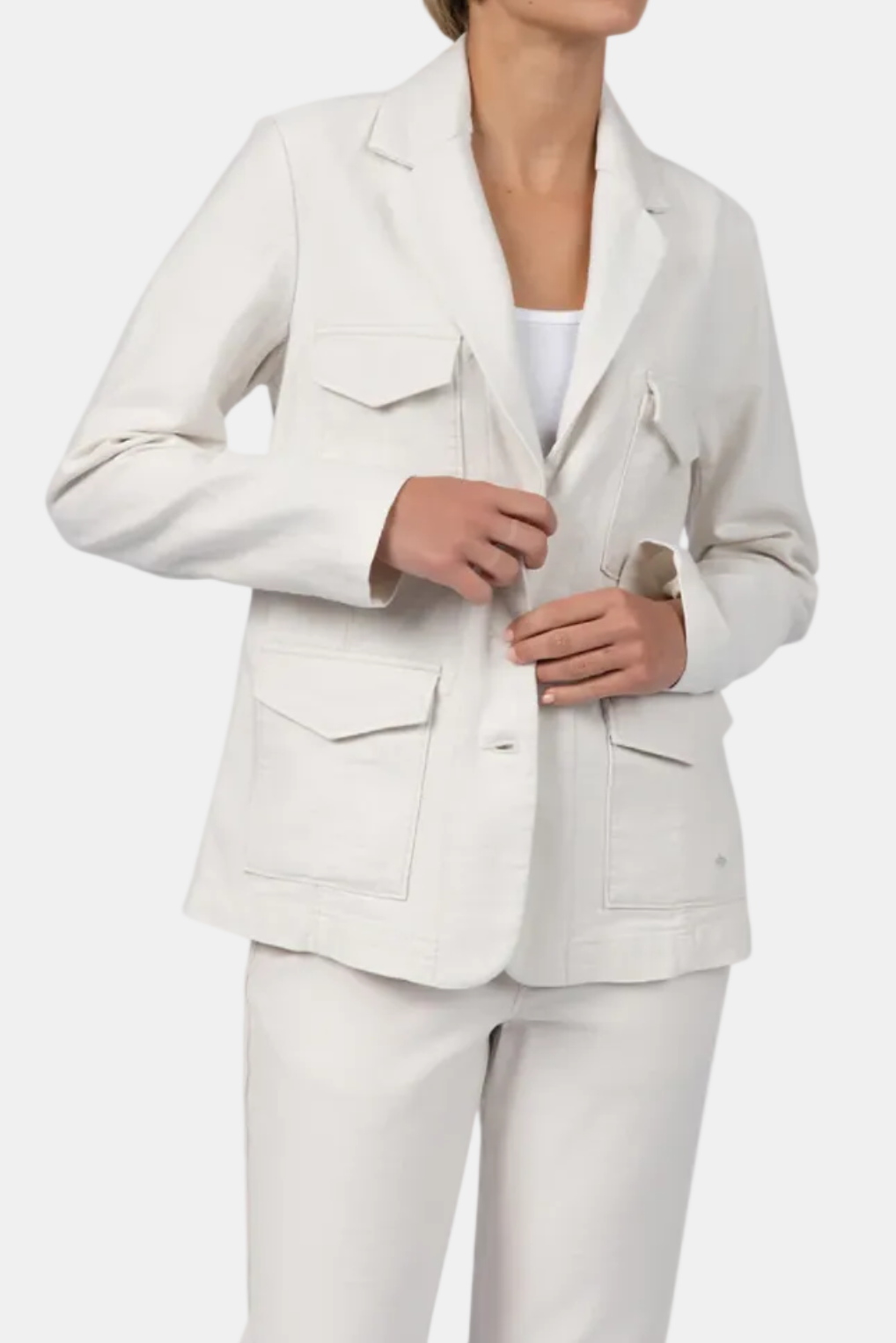 Woman wearing a light gray blazer and pants on a white background