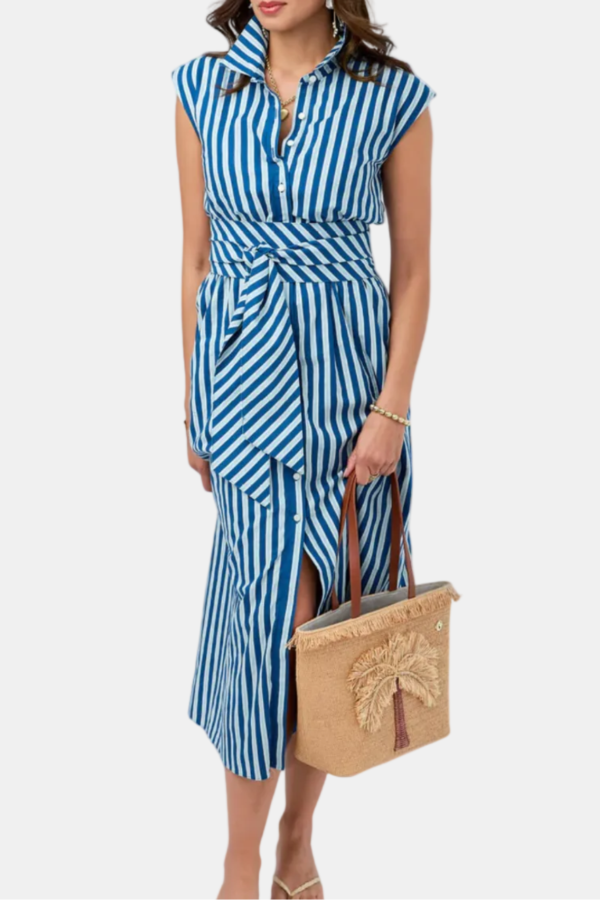 Woman wearing a blue and white striped dress holding a beige handbag on a white background